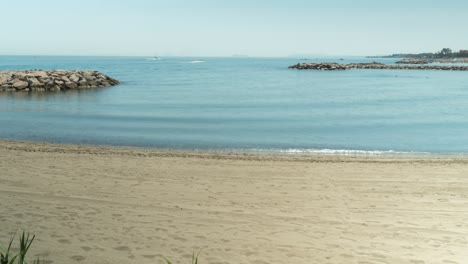 Tropical-Spain-coastline-beach-with-walking-people-and-boats,-time-lapse