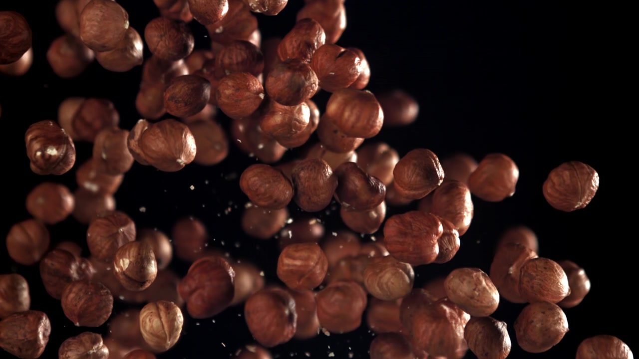 Nocciole pelate che cadono e galleggiano in super slow motion