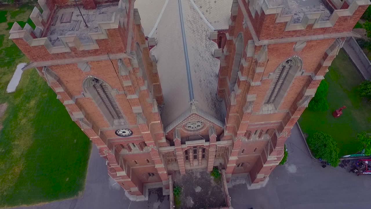 una hermosa vista aérea de la parte superior de la iglesia antigua, edificio rojo de la iglesia, árboles verdes y césped alrededor de la iglesia, cruz en la parte superior e inferior de la iglesia