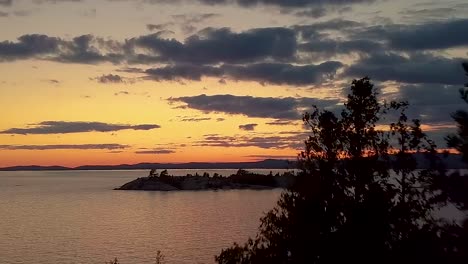 reveal of small island in lake just after sunset, drone aerial wide dolly in