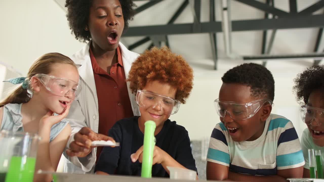 Diverse children, teacher watching boy dropping tablet into tube, starting reaction, foam rising