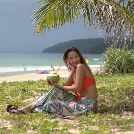 Glückliche-Frau-Mit-Kokosnussgetränk-Ruht-Am-Strand