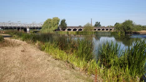 river trent with the trent railway line bridge in background, by ratcliffe on soar power station. wide shot