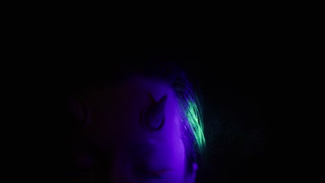 halloween concept. demon devil woman with red face and small horns on black background ideas for halloween body art, make up artist.