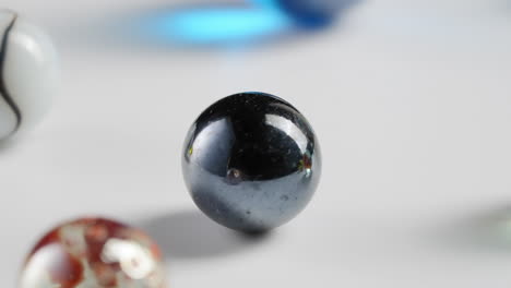 Attention-grabbing-transition-of-marbles-passing-on-rotating-white-background