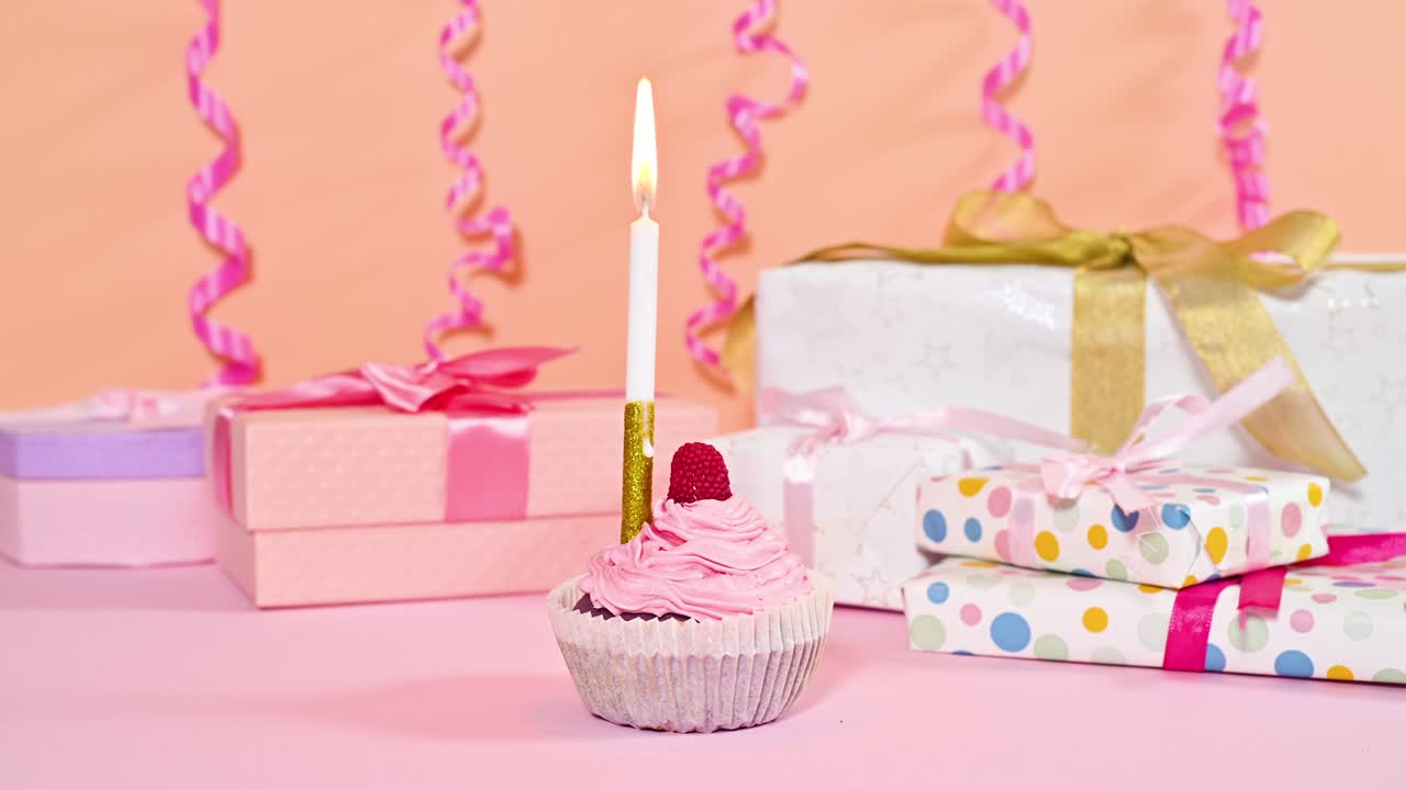 временная задержка остановить движение горящей рождественской свечи на сладком пироге с розовым кремом и подарками и лентами позади