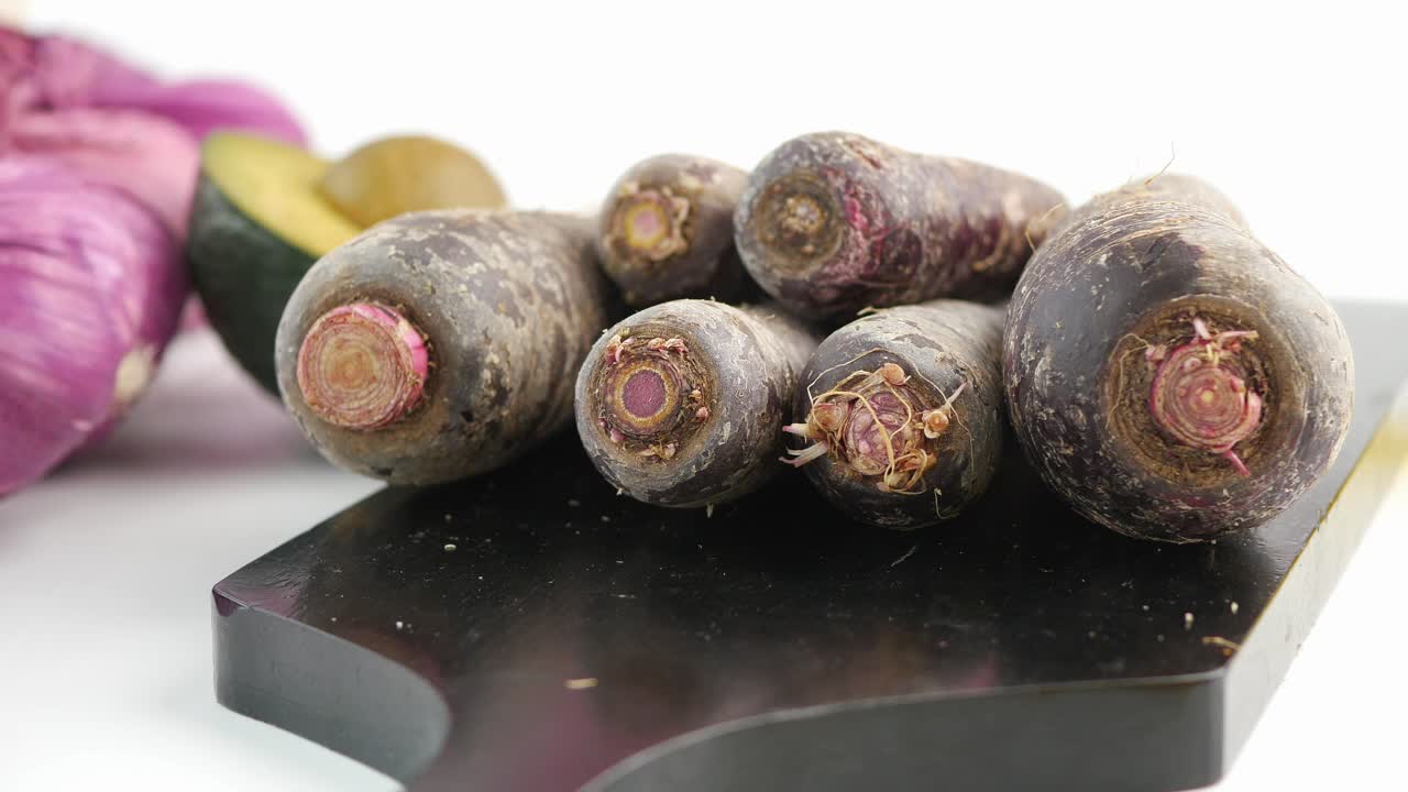 Black Carrots on a Cutting Board