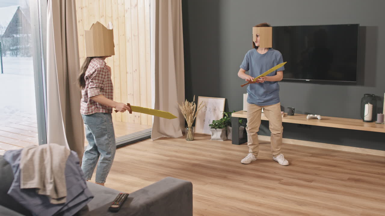 Søsken i papphjelmer som slåss med lekesverd