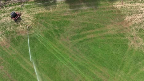 irrigation system watering dry and arid field during drought