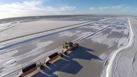 Toma-Aérea-De-Un-Gran-Camión-Lleno-De-Sal-En-Los-Salares-Por-Evaporación-Solar-En-Guerrero-Negro,-Laguna-Ojo-De-Liebre,-Reserva-De-La-Biosfera-De-El-Vizcaíno,-Baja-California-Sur