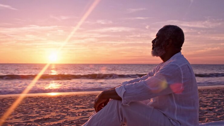 Un riflesso sereno al tramonto: un uomo pensieroso contempla la vita lungo la riva tranquilla mentre il sole scende all'orizzonte, avvolto dai caldi colori del tramonto