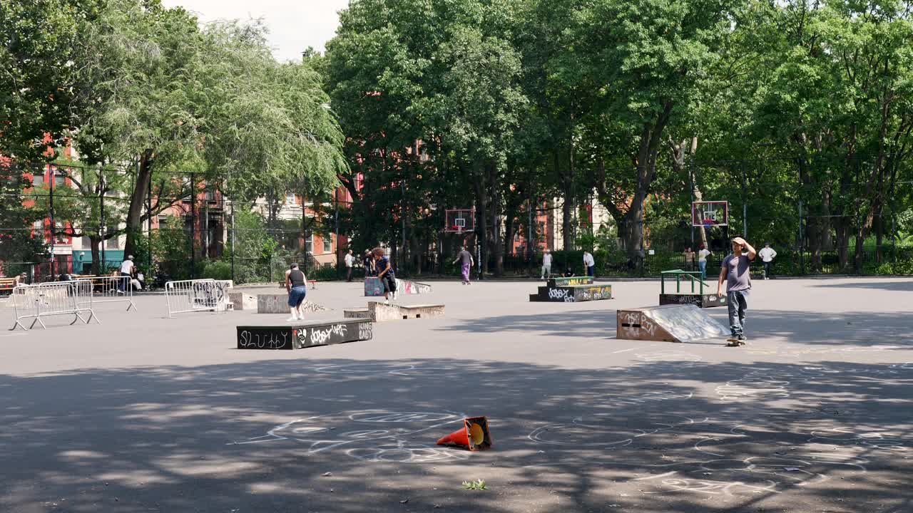 Slow motion landscape of Tompkins Square skatepark ramps ledges on basketball court suburbs of New York City Manhattan Brooklyn USA America sports fitness lifestyle