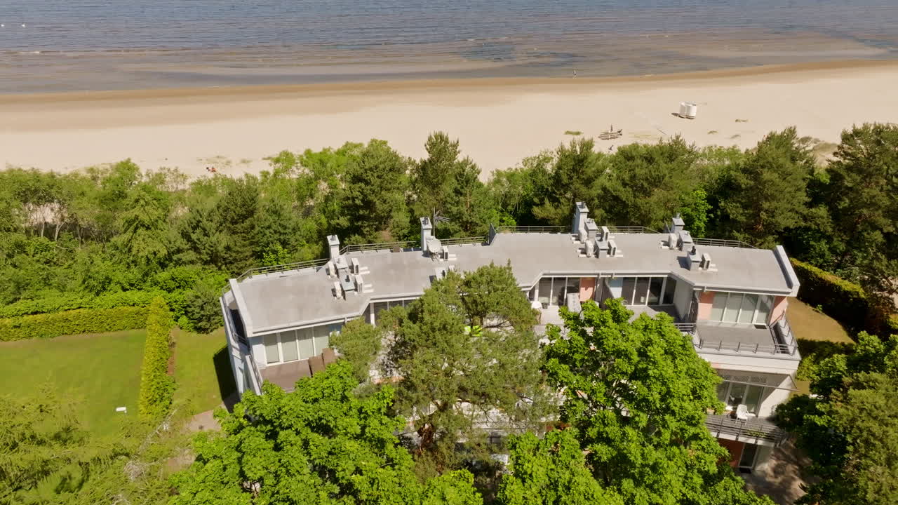 Aerial tracking shot overlooking of a seaview condos at a beach, summer in Latvia