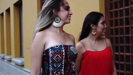 mujeres jóvenes con bolsas de compras apuntando a la ventana de la tienda al aire libre.