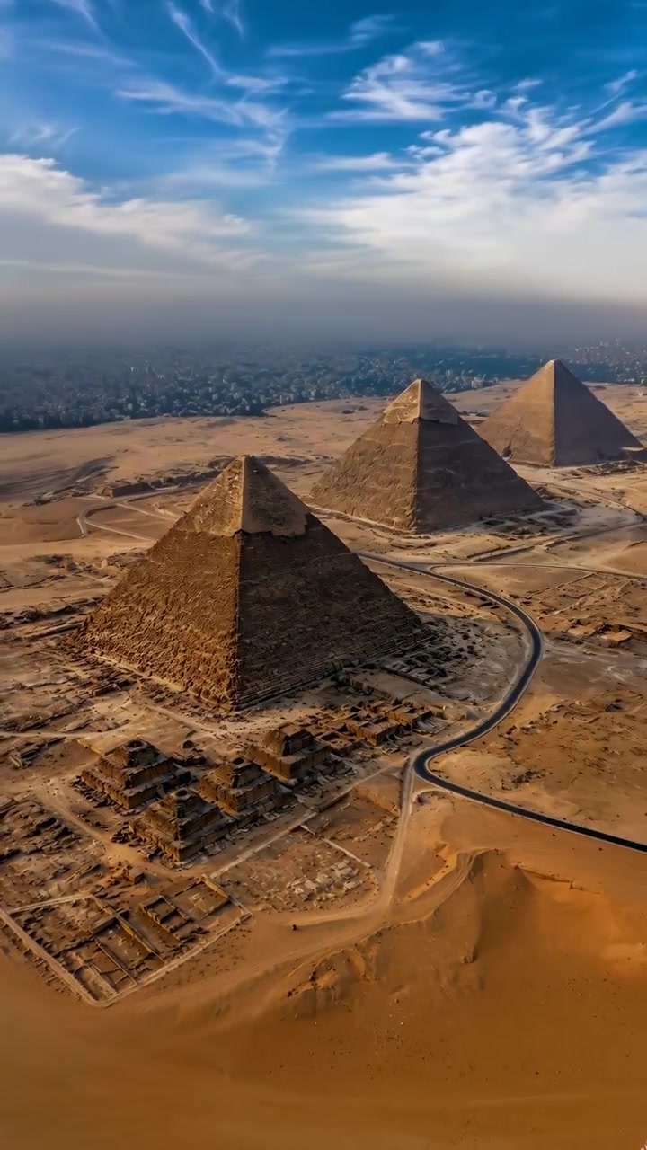 Inquadratura iniziale di una sequenza in un drammatico viaggio aereo sopra tre piramidi, con la piramide principale in primo piano in basso a sinistra e altre due piramidi a destra.