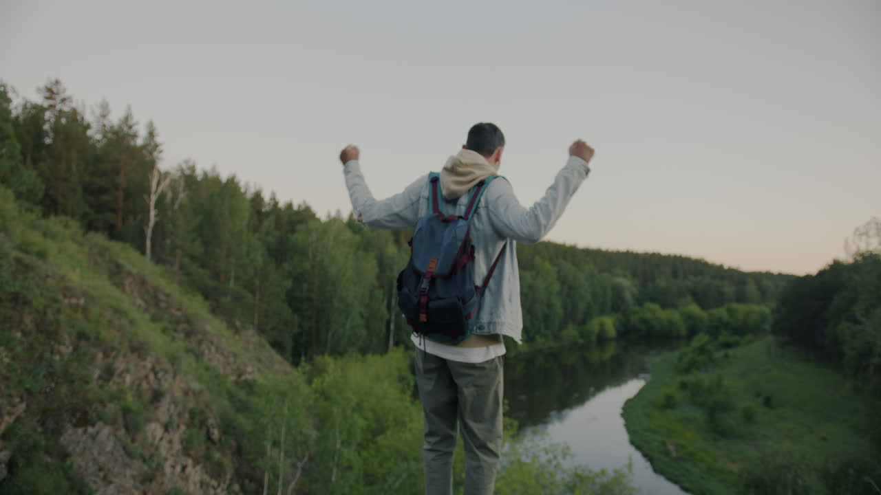 Man Hiking in a Forest with a River View