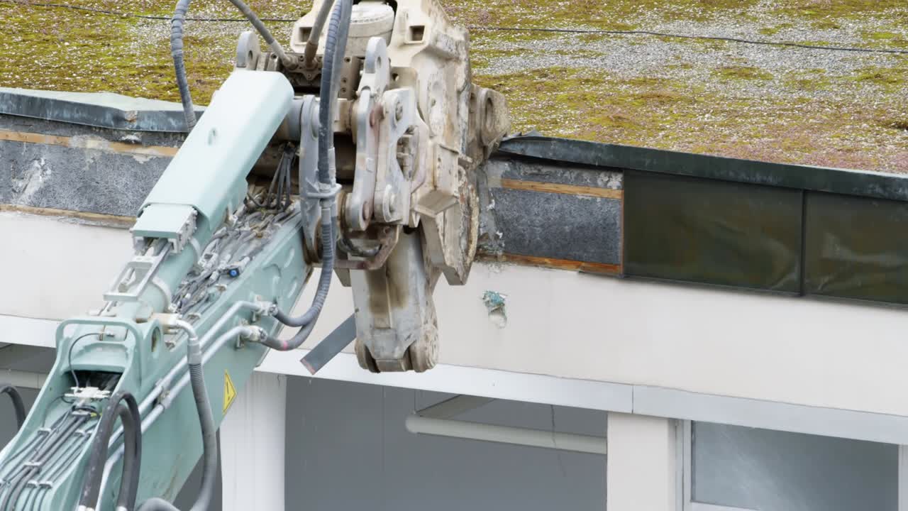 폐기된 건물의 지붕을 부수는 철거 기계