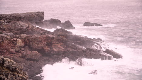 waves crashing into the coastline of portugal