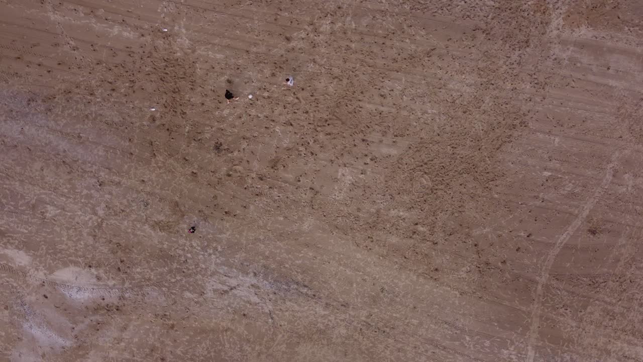 모래 해변에서 축구를 하는 아이들의 공중 하향식 샷 - 골키퍼가 공을 구합니다, 4k