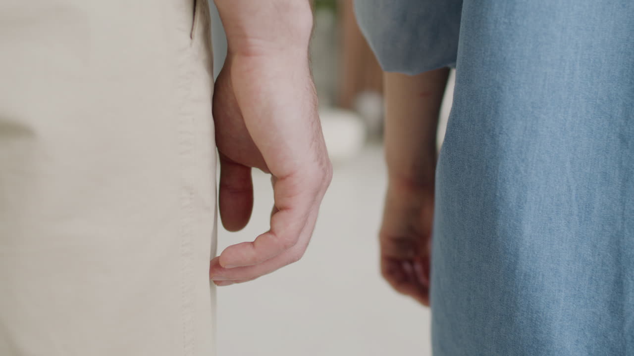 집에서 서서 손을 잡고 인식할 수 없는 부부의 닫습니다