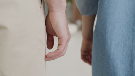 Close-Up-Of-An-Unrecognizable-Couple-Standing-And-Holding-Hands-At-Home