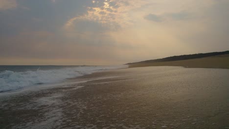 Lufttiefflug-über-Leeren-Oaxaca-Strand-Mit-Lichtstrahlen-Bei-Sonnenuntergang