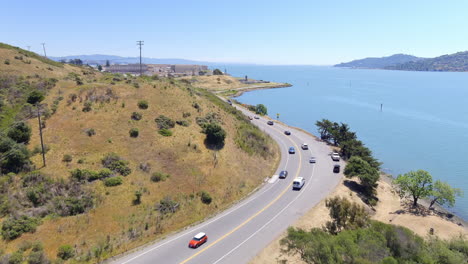 Vista-Aérea-De-Una-Carretera-Costera-Que-Luego-Asciende-Para-Revelar-La-Prisión-Estatal-De-San-Quentin-En-La-Costa-De-La-Bahía-De-San-Francisco