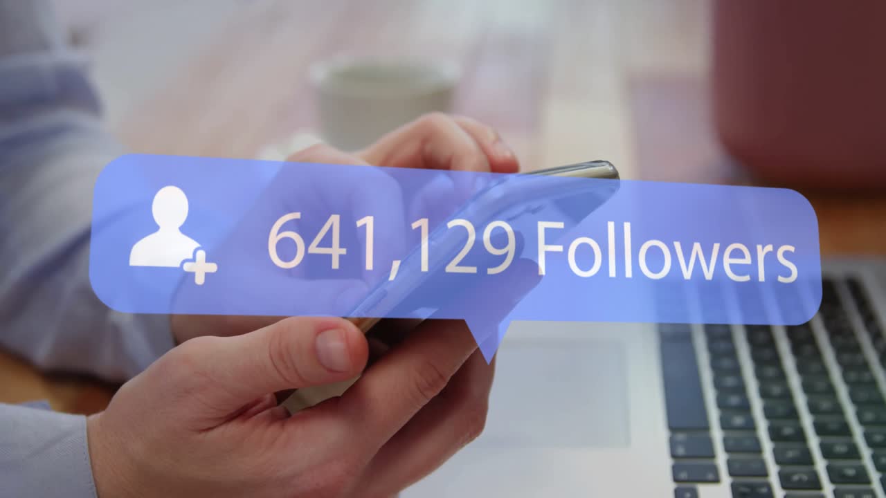 hands holding smartphone on laptop tapping screen updating follower count for monitoring profile