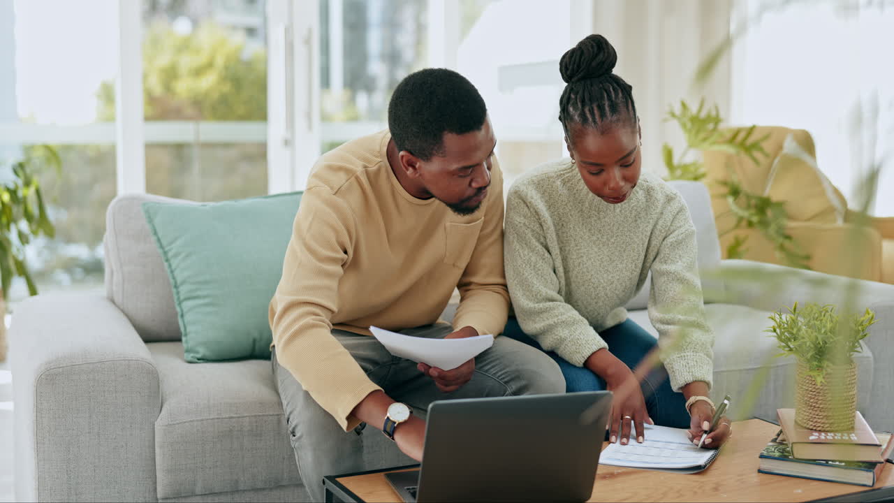 Black couple writing, laptop