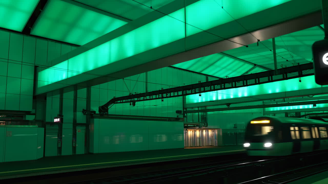 Treno della metropolitana in movimento attraverso una stazione moderna con illuminazione verde
