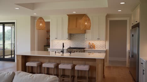 medium shot of a spacious kitchen with white countertops, cupboards, and light wood accents