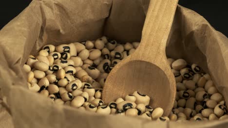 food detail: paper bag of dried black-eyed peas rotates in close-up