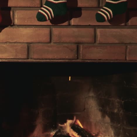 Weihnachtsgeschenksocken-Hängen-über-Dem-Kamin,-Wo-Das-Feuer-Brennt-1