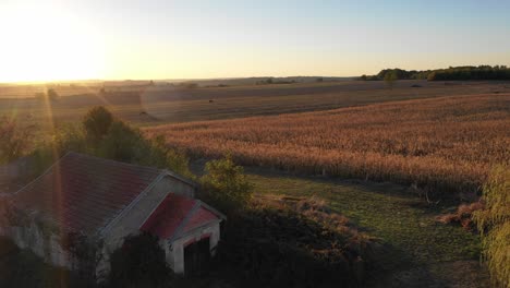 Sonnenuntergang-Ländliche-Landschaft-Bei-Sonnenaufgang-Mit-Goldenen-Sonnenstrahlen,-Die-Die-Weiten-Felder-Und-Farmen-Beleuchten