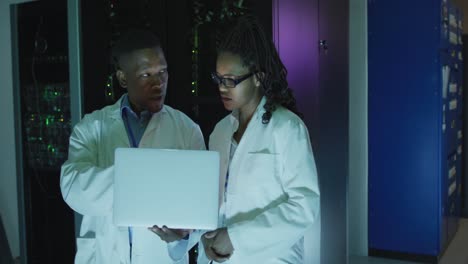 African-american-computer-technicians-using-laptop-working-in-business-server-room