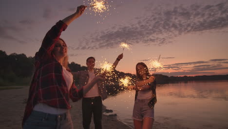 Beautiful-women-in-summer-with-sparklers-dancing-in-slow-motion-on-the-beach-at-night