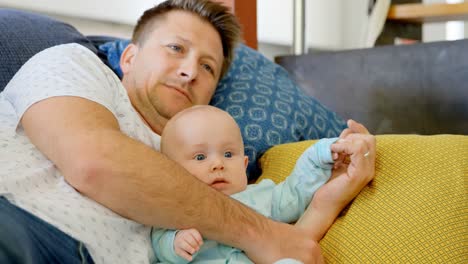 Padre-Y-Bebé-Viendo-Televisión-En-La-Sala-De-Estar-4k