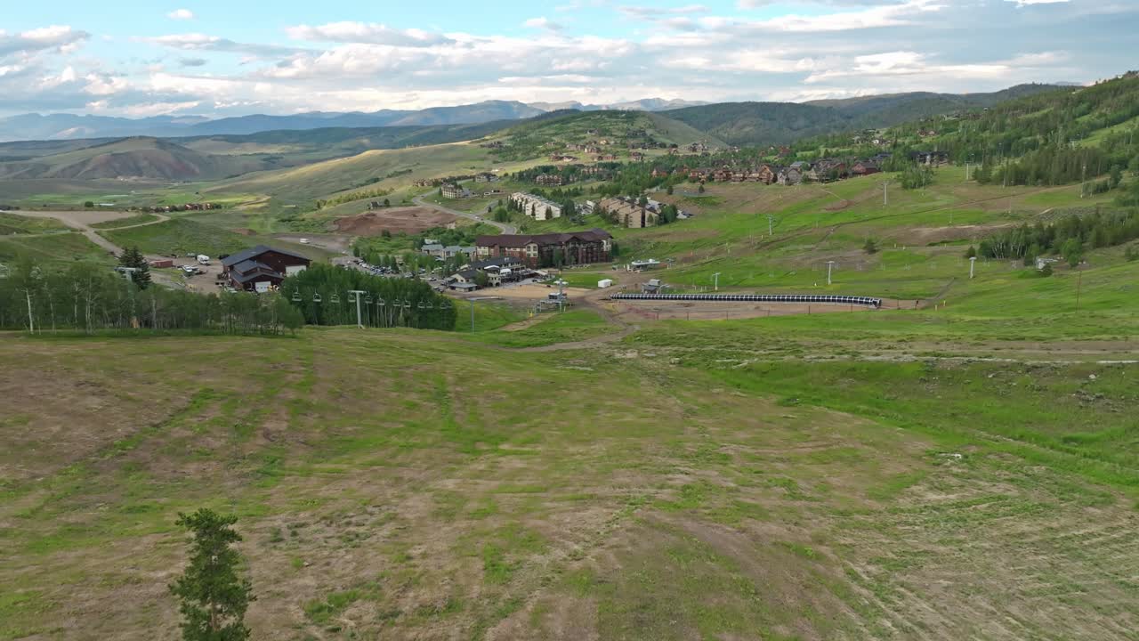 dolly aéreo por encima de la exuberante ladera verde de la montaña de skir resort en colorado, verano