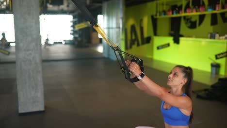 mujer trabajando con bandas de resistencia en el gimnasio