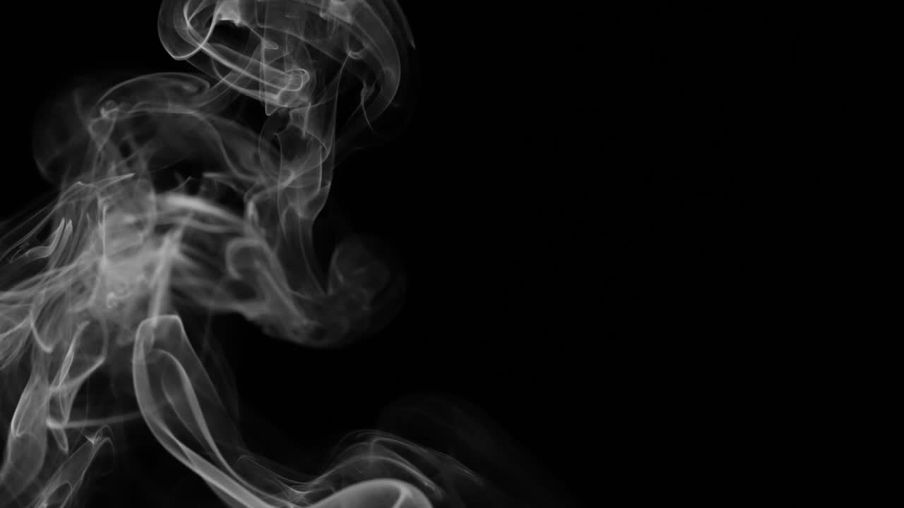 una traccia di fumo con forme uniche e vortici isolati su uno sfondo nero
