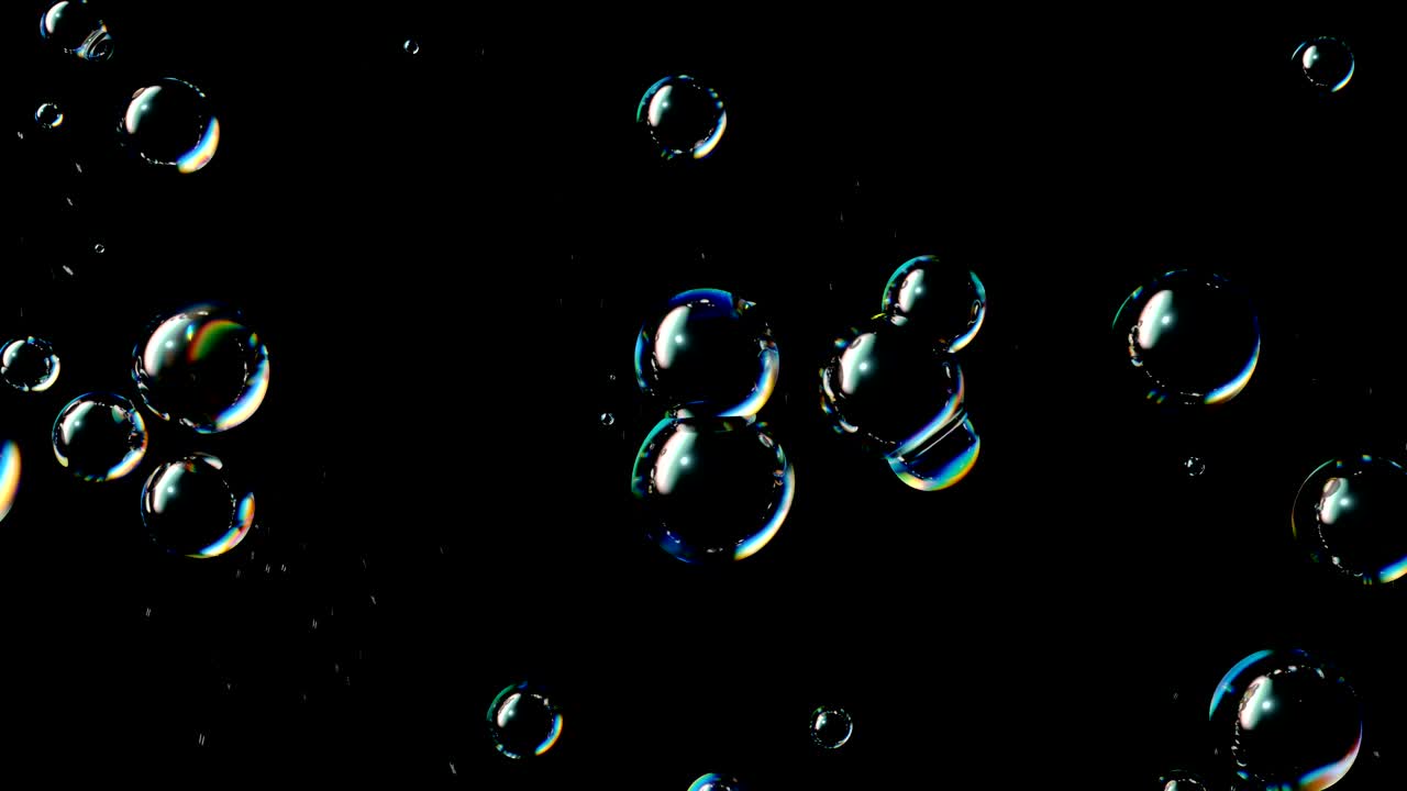 Soap Bubbles Grow and Burst on a Black Background
