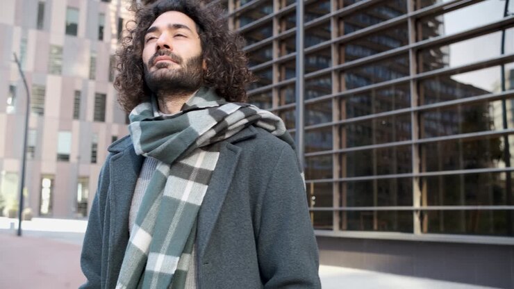 Uomo d'affari in abiti casual eleganti che guarda altrove in posa epica nel quartiere finanziario.
