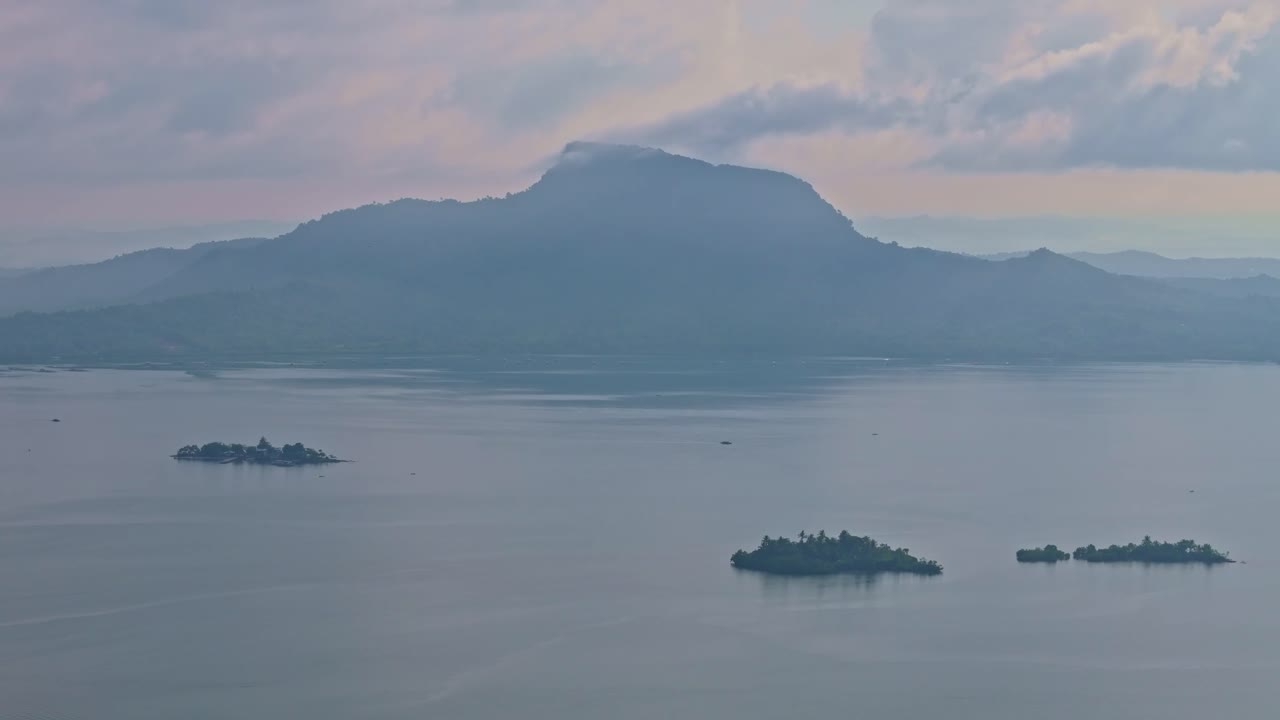 Misty mountains rise behind calm waters as dawn breaks over San Juanico Strait, Leyte