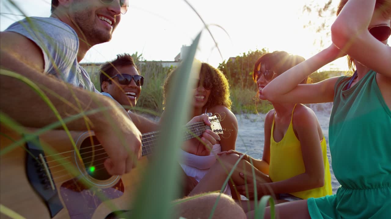 personas multiétnicas felices relajándose con picnic en la playa