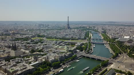 Amazing-aerial-ascending-footage-of-landmarks-in-European-metropolis.-Boats-moving-on-calm-water-in-Seine-river,-historic-Les-Invalides-and-tall-Eiffel-Tower.-Paris,-France