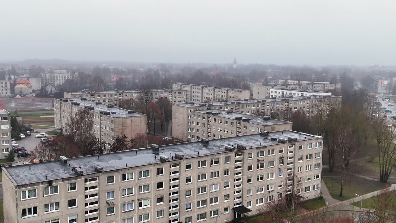 Rising, establishing drone shot of block building district in cold winter day without snow