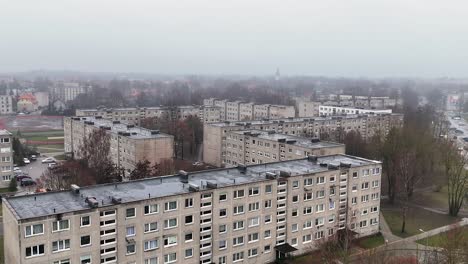 rising, establishing drone shot of block building district in cold winter day without snow