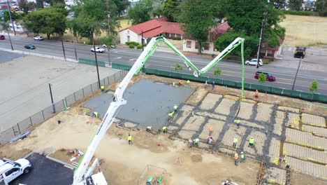 Remarkable-Aerial-Over-Construction-Site-With-Giant-Crane-And-Workers-Pouring-Concrete-Foundation-In-Ventura-California-4