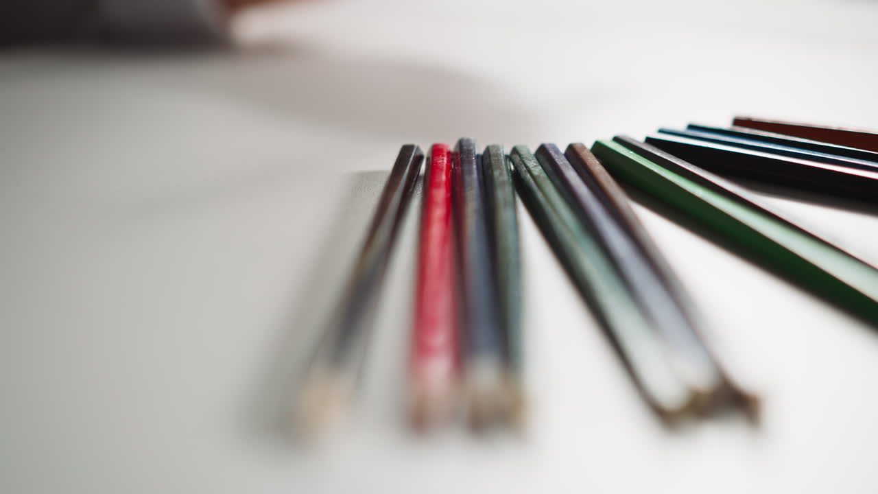 작은 소녀는  ⁇  종이에 노란 연필 그림을 그립니다