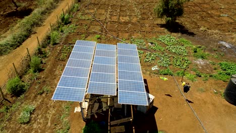 aerial drone view into large solar panels at a solar farm at bright sunset